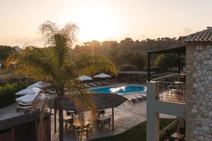 a resort with a pool and a palm tree at Tsokas Hotel in Finikounta
