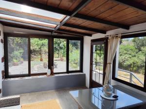 uma sala de estar com janelas grandes e uma mesa de vidro em Casa Julián em Garafía