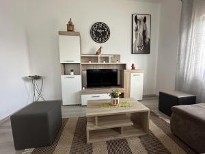 a living room with a tv and a couch and a table at Holiday Home Kate in Pridraga