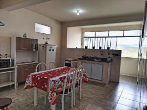 una cocina con una mesa con un mantel rojo. en Casinha da Lela, en Ouro Preto