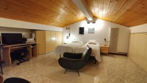 a hotel room with two beds and a desk and a television at Casa Il Volo in San Zeno di Montagna