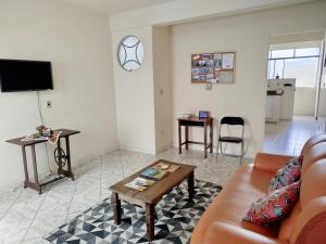 ein Wohnzimmer mit einem Sofa und einem Tisch in der Unterkunft Casinha da Lela in Ouro Preto