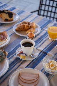 a table with plates of food and a cup of coffee at Tsokas Hotel in Finikounta