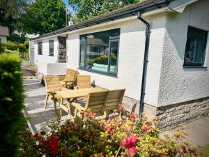 einen Holztisch und Stühle außerhalb eines Hauses in der Unterkunft 3-bedroom bungalow, central Ambleside with parking in Ambleside