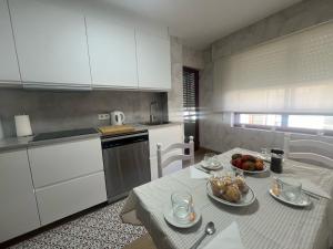 a kitchen with a table with a bowl of fruit on it at Puerto de Bueu, Centro in Bueu +21 photos
