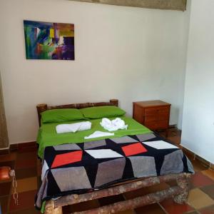 ein Schlafzimmer mit einem Bett mit zwei Handtüchern darauf in der Unterkunft AZULEJO in Jericó