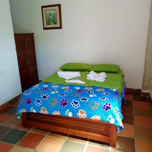 a bedroom with a bed with a blue comforter at AZULEJO in Jericó