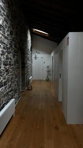 an empty room with a stone wall and wooden floors at Izal Landetxea in Bergara