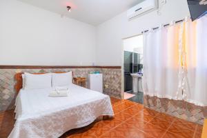 - une chambre avec un lit blanc et une salle de bains dans l'établissement Pousada Meia Lua, à Pirenópolis