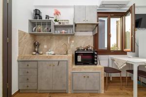 a kitchen with a sink and a microwave at Seagull House 3 in Ayía Kiriakí