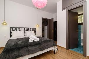 a bedroom with a large bed and a pink chandelier at Seagull House 3 in Ayía Kiriakí