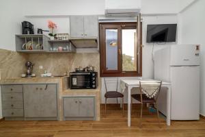 a small kitchen with a table and a desk at Seagull House 3 in Ayía Kiriakí