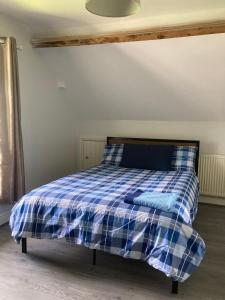 uma cama com um cobertor xadrez azul e branco em Springhome Newport em Newport