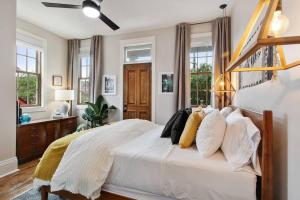 a bedroom with a bed with white sheets and pillows at Designer Home Walking Distance To The French Quarter's in New Orleans +10 photos