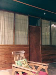 einem Schaukelstuhl aus Holz vor einem Haus in der Unterkunft JARDIN DE LAS MUSAS in Puerto Maldonado