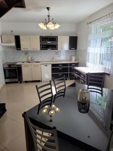 a kitchen with a table and chairs in a kitchen at Dom wakacyjny MERLIN nad jeziorem Jodłów Sława Radzyń in Jodlow