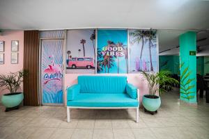 Sofá azul en una habitación con palmeras en Taybo Beach By St Hoteles, en Santa Marta