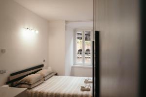 een slaapkamer met een bed en een raam bij Appartamento Al Borgo in Bienno