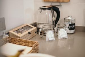 un bancone della cucina con bollitore per il tè e un cesto. di Appartamento Al Borgo a Bienno