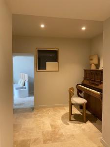 a living room with a piano and a chair at Mas provençal d'exception in La Garde-Adhémar