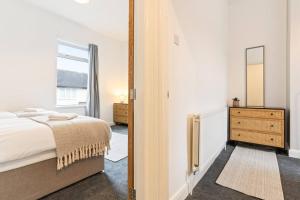 Un dormitorio con una cama, una cómoda y un espejo. en Herschell House - Central Location - Free Parking, Fast Wifi, SmartTV with Netflix by Yoko Property, en Redcar