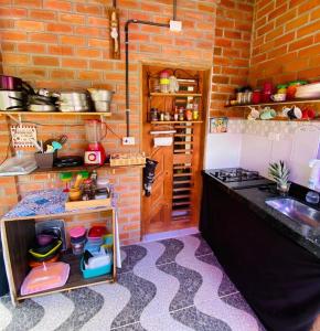 uma cozinha com um balcão e um lavatório num quarto em Canoa Roots Hostel & Camping em Canoa Quebrada