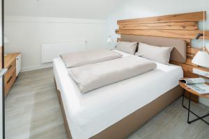 a bedroom with a large white bed and a desk at Nordstrandperle Ap O3 in Norderney