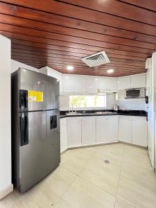 cocina con armarios blancos y nevera de acero inoxidable en Edificio Bay Point Apartmento 307, en San Andrés