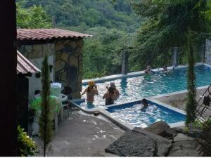 a group of people playing in a swimming pool at FINCA QUINTA LOS CEDROS in Xilitla