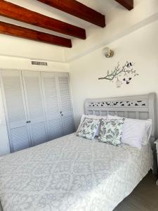 1 dormitorio con 1 cama con sábanas y almohadas blancas en Edificio Bay Point Apartmento 307, en San Andrés