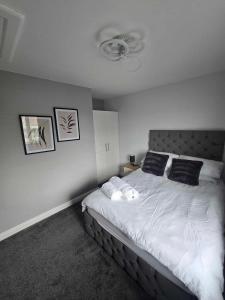 een slaapkamer met een bed met witte lakens en zwarte kussens bij Perfect Getaway / Workstay! in Middlesbrough