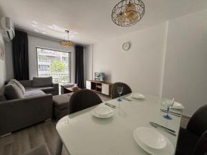 ein Wohnzimmer mit einem weißen Tisch und Stühlen in der Unterkunft Luxury Inn:2BR Amazing Garden View in Madinaty B10 in Madinaty