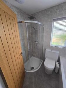 uma casa de banho com um chuveiro e um WC branco em Perfect Getaway / Workstay! em Middlesbrough