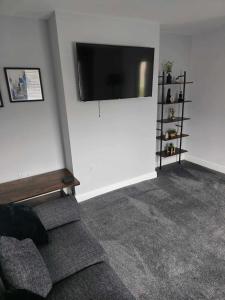 uma sala de estar com um sofá e uma televisão de ecrã plano na parede em Perfect Getaway / Workstay! em Middlesbrough