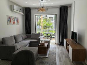 een woonkamer met een bank en een tv bij Luxury Inn:2BR Amazing Garden View in Madinaty B10 in Madinaty