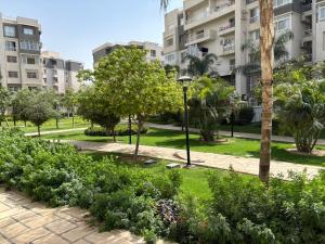 een park met bomen, struiken en gebouwen bij Luxury Inn:2BR Amazing Garden View in Madinaty B10 in Madinaty