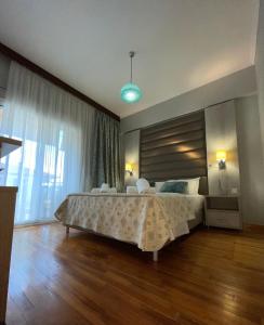 1 dormitorio con cama grande y ventana grande en Maria Apartments, en Paralia Dionisiou