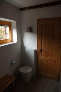 une salle de bain avec toilettes et porte en bois dans l'établissement Ferienhaus Anno 1720, à Wernigerode 13 autres photos