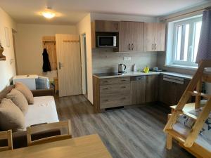 a living room with a couch and a kitchen at Apartmán Nová Pec - Lipno, Šumava in Prachatice