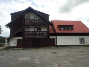 a large house with a red roof and a building at Apartmán Nová Pec - Lipno, Šumava in Prachatice
