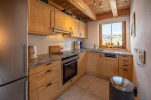 a small kitchen with wooden cabinets and a window at Almhäuser Filzsteinalpe Almhaus 197 in Krimml +6 photos