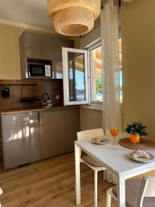 a kitchen with a white table and chairs and a window at Studio apartman Mia in Murter
