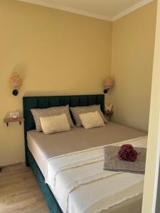 a bed with a green headboard in a bedroom at Studio apartman Mia in Murter +3 photos