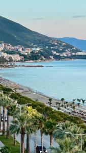 een uitzicht op een strand met palmbomen en de oceaan bij Marina Premium Hotel in Vlorë
