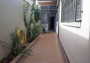 an empty walkway leading to a building with a door at Suíte Aconchegante Jd São Luiz Ótima Localização in Ribeirão Preto