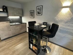 a kitchen with a table and two chairs and a counter at Geheimtipp KÖNIGSSTUHL - Altstadt-Apartment nahe Warnowufer in Rostock