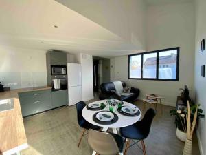 a kitchen and a living room with a table and chairs at Le Tropical, Maison T3 - 55m2 in Poitiers