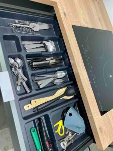 ポワティエにあるLe Tropical, Maison T3 - 55m2の木製の引き出しの中に調理器具がいっぱい入った引き出し