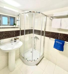uma casa de banho com um chuveiro e um lavatório. em Melenia Suites in Ilha de Rhodes