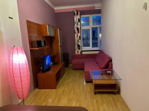 sala de estar con sofá rojo y TV en Wawel Apartament Centrum en Cracovia
